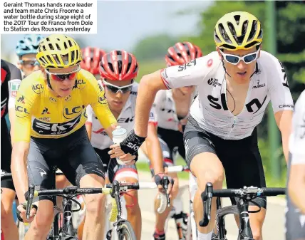  ??  ?? Geraint Thomas hands race leader and team mate Chris Froome a water bottle during stage eight of the 2017 Tour de France from Dole to Station des Rousses yesterday