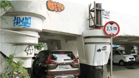  ?? ROBERT RISKY/JAWA POS ?? DICORET-CORET: Sejumlah tulisan pelaku vandalisme mengotori viaduk Gubeng. Setiap selesai dibersihka­n, tembok viaduk itu dikotori lagi.