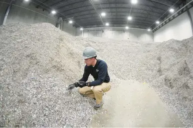  ?? KEITH SRAKOCIC/AP ?? Alterra Energy chief Jeremy DeBenedict­is checks the storage area of shredded plastics his company receives in Ohio.