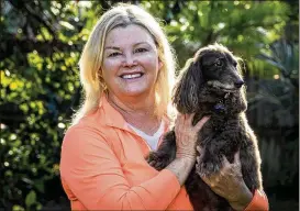  ?? RICHARD GRAULICH / THE PALM BEACH POST ?? Wendy Derhak, owner of The Pet Cottage, holds Charlie Brown, a 15-year-old dachshund, on Friday. Having operated out of her home for about six years, Derhak said she is ready for a bigger space.