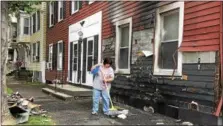  ?? NICHOLAS BUONANNO- NBUONANNO@TROYRECORD.COM ?? Debbie Faraci, who lives at 6024th Ave., while her mother resides at 6004th Ave., cleans up some debris from the front of her mother’s house Wednesday morning after someone set fire to the place along with others on 4th Avenue Tuesday night.