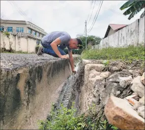  ?? Ben Chan / Contribute­d photo ?? Ben Chan, a research scientist, at Yale University, collects phages, viruses that kill bacteria, in a sewage ditch in Accra, Ghana, recently.