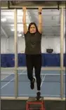  ?? (Arkansas Democrat-Gazette/Celia Storey) ?? Maria Rogers, club youth director, uses a chin-up bar for Arm Hang Traction in the fitness room of Little Rock Racquet Club’s tennis center.