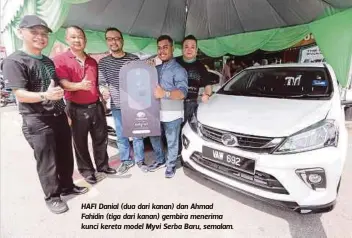  ??  ?? HAFI Danial (dua dari kanan) dan Ahmad Fahidin (tiga dari kanan) gembira menerima kunci kereta model Myvi Serba Baru, semalam.