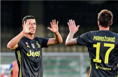  ?? — AFP ?? Juventus’ Cristiano Ronaldo celebrates with teammate Mario Mandzukic at the end of their match against AC Chievo.