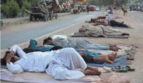  ?? FAREED KHAN/AP ?? Vendors and rickshaw drivers sleep in the open early on a hot June morning in Karachi, Pakistan, as parts of the country continued to experience an intense heat wave.