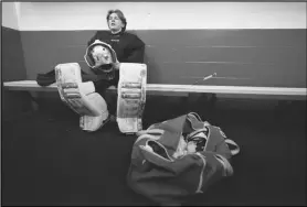  ?? Associated Press ?? Evan Smolik sits in a dressing room before a hockey practice, Nov. 29, in Edina, Minn. When Evan was 14, a teammate’s skate struck his neck and his jugular vein, but the neck guard he was wearing prevented the skate from cutting his carotid artery and helped save his life.