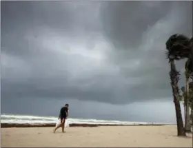  ?? PAUL CHIASSON — THE CANADIAN PRESS VIA AP ?? A man walks along the beach with heavy winds and threatenin­g skies in Hollywood, Fla., as Hurricane Irma approaches the state on Saturday.