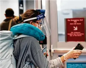  ?? Yi-Chin Lee / Houston Chronicle ?? Una pasajera de United Airlines escanea su boleto frente a una máquina antes de abordar su vuelo en el George Bush Interconti­nental Airport de Houston.