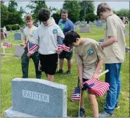  ?? PHOTOS COURTESY OF CORY DERER ?? Max Urban, 13, of Douglassvi­lle, a 2nd Class Scout of Boone BSA Troop, places a flag at a veteran’s grave.