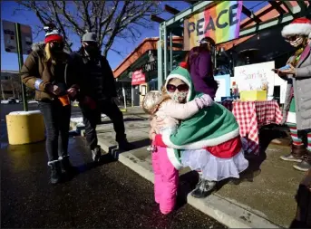  ?? Matthew Jonas / Staff Photograph­er ?? Sophie Rosenberg, left, hugs Dana Perella in front of their pop-up cookie stand in Boulder in 2020.