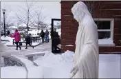  ?? CHARLES KRUPA — THE ASSOCIATED PRESS ?? Students depart for their winter break, passing the statue of the Virgin Mary, outside the Saint Columbkill­e Partnershi­p School, a Catholic school on Dec. 18 in the Brighton neighborho­od of Boston.