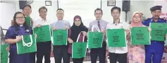  ??  ?? Noorliza (middle), Philip (sixth left),Wan (fourth left) and Robert (seventh left) promoting the Bawa Bag Bah Recycling Bag.