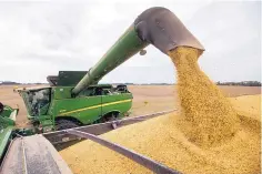  ?? MICHAEL CONROY/ASSOCIATED PRESS ?? Mike Starkey offloads soybeans from his combine as he harvests his crops in Brownsburg, Indiana. The escalating trade war between the U.S. and China is causing anxiety among rural farmers and bankers.