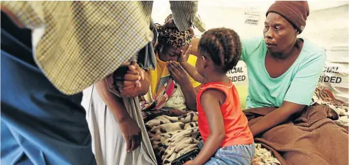  ?? PHOTOS / SANDILE NDLOVU ?? Banele Mkhwanazi, 3, wipes away tears from her mother Sibongile’s face as she cries over the death of her son Sphesihle. Sibongile’s mother Favourite Mkhwanazi also couldn’t hold back her tears.