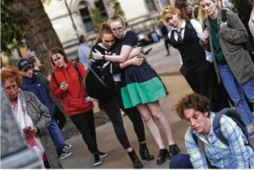  ?? Emilio Morenatti / Associated Press ?? People attend a vigil in Albert Square in Manchester, England, on Tuesday, the day after the suicide bombing at an Ariana Grande concert that killed 22 people. It is the deadliest terrorist strike in Britain since 2005.