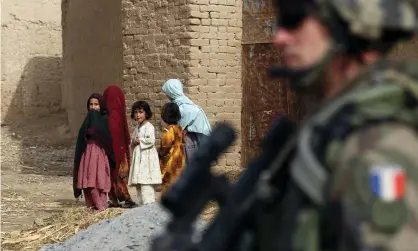  ?? Photograph: Thomas Coex/AFP ?? ‘Let me state categorica­lly, our service people are not to blame.’ Afghan girls look at a French soldier in Showal town, Helmand, in 2010.