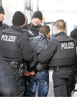  ?? Foto: dpa ?? Polizisten führen einen straffälli­g gewordenen Asylbewerb­er in Sachsen ab.