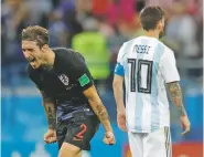  ?? PAVEL GOLOVKIN/ASSOCIATED PRESS ?? Argentina’s Lionel Messi, right, leaves the pitch as Croatia’s Sime Vrsaljko celebrates his side’s 3-0 victory at the end of the Group D match Thursday at the World Cup in Novgorod, Russia.