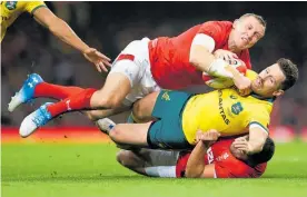  ?? Photo / Getty Images ?? Bernard Foley is sandwiched by two Welsh defenders.