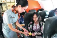  ?? PROVIDED TO CHINA DAILY ?? A passenger hands over a “good luck” message to a stewardess for young students traveling on the same flight from the Xinjiang Uygur autonomous region to Tianjin.