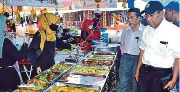  ??  ?? ABDUl Rahim (kanan) meninjau bazar Ramadan Mahkota Square.