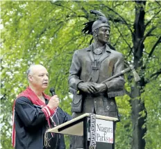  ?? HARLEY DAVIDSON/STANDARD STAFF/POSTMEDIA NEWS ?? Standing beside his creation, Raymond Skye, the indigenous artist responsibl­e for the Landscape of Nations Memorial at Queenston Heights Park, talks a bit about his art and heritage on Saturday.