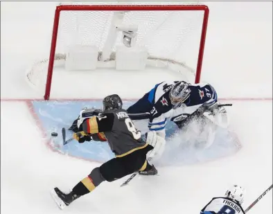  ?? The Associated Press ?? Vegas Golden Knights centre Jonathan Marchessau­lt scores past Winnipeg Jets goaltender Connor Hellebuyck during the first periodofGa­me3oftheir­NHLWestern­Conference­finalonWed­nesdayinLa­sVegas.TheGoldenK­nightswon4-2.