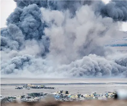  ?? KUTLUHAN CUCEL/ GETTY IMAGES/ FILE ?? Smoke and dust rise over the Syrian town of Kobani after an airstrike last year, as seen from the Turkish border.