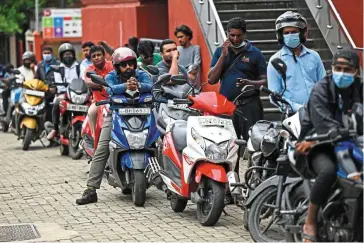  ?? — AFP ?? In dire straits: Motorists queue along a street to buy fuel in Colombo. Cash-strapped Sri
Lanka is seeking aid from the IMF as it seeks measures to avoid further suffering for the country’s 22 million people.