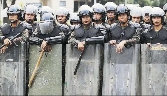  ?? EPA-EFE ?? Anti-riot police secure the perimeter during a protest at the Libingan ng mga Bayani in Taguig City yesterday. Activists staged a protest at the burial site of the late dictator Ferdinand Marcos during his birth anniversar­y yesterday.