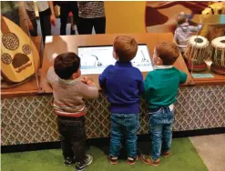  ??  ?? Youngsters interact with a display of musical instrument­s at Children's Museum of Manhattan, during the exhibition "America to Zanzibar: Muslim Cultures Near and Far," in New York.