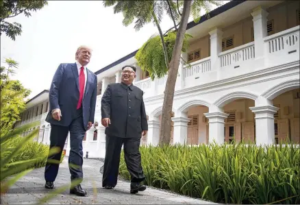  ?? DOUG MILLS/NEW YORK TIMES ?? President Donald Trump (left) and North Korean leader Kim Jong Un walk after lunch Tuesday on Sentosa Island in Singapore. Though the two countries do not have formal diplomatic relations, all of the pageantry pointed to a meeting between near equals.