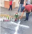 ??  ?? Ofrenda. Habitantes colocaron velas y flores en el lugar donde quedaron tendidos los cuerpos de los policías.
