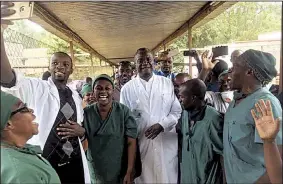  ?? AP/Norwegian Church Aid ?? Denis Mukwege (center) celebrates his Nobel Peace Prize award with the staff Friday at his Panzi Hospital in Bukavu, Congo, where he has treated many rape victims.