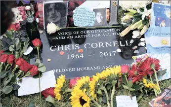  ??  ?? A plaque marking Chris Cornell’s grave site, covered in guitar picks, flowers, photos and notes, after the singer’s funeral at the Hollywood Forever Cemetery in Los Angeles on Friday. Picture: AP