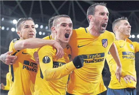  ??  ?? Atletico Madrid’s Antoine Griezmann, second left, celebrates with teammates after scoring against Arsenal.
