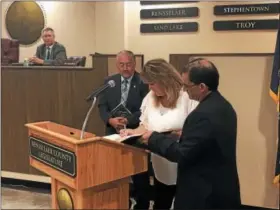  ?? NICHOLAS BUONANNO- NBUONANNO@TROYRECORD.COM ?? Newly appointed Rensselaer County Legislatur­e Kim Ashe-McPherson, C-Troy, signs the oath of office after being appointed and sworn in as a new county legislator Tuesday night.