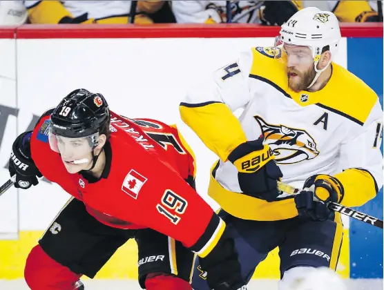  ?? JEFF McINTOSH/THE CANADIAN PRESS ?? Nashville defenceman Mattias Ekholm checks Flames forward Matthew Tkachuk during Friday’s game at the Saddledome. The Predators won 5-3.