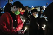  ?? JOE LAMBERTI / CAMDEN COURIER-POST ?? People gather for a vigil Wednesday in Philadelph­ia to mourn and confront the rising violence against Asian Americans. The vigil was held after a shooting in Atlanta that killed eight people.