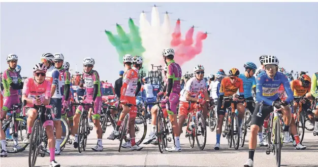  ?? FOTO: MARCO ALPOZZI/DPA ?? Die Fahrer beim Giro d'Italia stehen am Sonntag am Start, während im Hintergrun­d die Kunstflugs­taffel der italienisc­hen Luftwaffe am Himmel eine Flugshow präsentier­t.