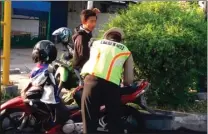  ?? SUDRAJAT/JAWA POS ?? BELUM KAPOK JUGA: Polisi memberikan surat tilang kepada seorang pelajar bermotor di Jalan Raya Jenggolo kemarin.