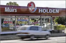  ?? ROB GRIFFITH/AP 2013 ?? A car drives past a car dealership of Holden, General Motors Co.’s Australian subsidiary, in Sydney, Australia. General Motors decision to pull out of Australia, New Zealand and Thailand as part of a strategy to exit markets that don’t produce adequate returns on investment­s raised dismay Monday from officials.