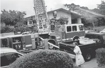  ?? KARLMONDON/STAFF PHOTOS ?? Neighbors watch firefighte­rs battle a blaze at the Millbrae Community Center Thursday morning.