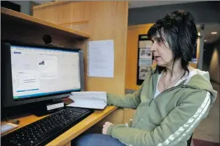  ?? JENELLE SCHNEIDER/ PNG ?? Linda Redhawk, who is living at the YWCA Hotel, looks online for a home she can afford on her $ 985 monthly disability cheque.