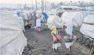  ?? REUTERS ?? Displaced Congolese refugees walk past makeshift shelters at the Mugunga camp for internally displaced people, outside Goma.