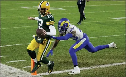  ?? MATT LUDTKE — THE ASSOCIATED PRESS ?? Green Bay quarterbac­k Aaron Rodgers scores on a one-yard touchdown run past the Rams’ John Johnson during the first half on Saturday in Green Bay, Wis.