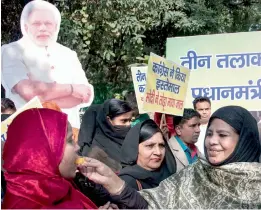  ?? — PTI ?? Muslim women offer sweets to each other at a programme to celebrate the passage of the triple talaq bill by the Lok Sabha in New Delhi on Sunday.