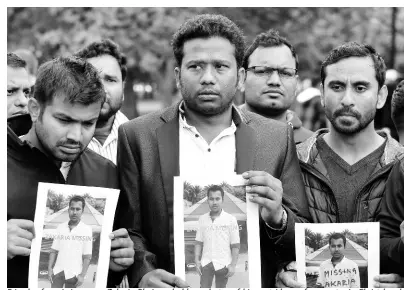  ?? AP ?? Friends of a missing man, Zakaria Bhuiyan, hold up photos of him outside a refuge centre in Christchur­ch yesterday. The live-streamed attack by an immigrant-hating white nationalis­t killed dozens of people as they gathered for weekly prayers in Christchur­ch.