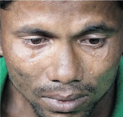  ?? GEMUNU AMARASINGH­E / THE ASSOCIATED PRESS ?? Alam Jafar, a 25-year- old farmer, cries as he recounts the tragic story of his journey from Myanmar to Bangladesh, part of the largest exodus in Asia since the Vietman War — a human tide of more than 500,000 Rohingya Muslims.